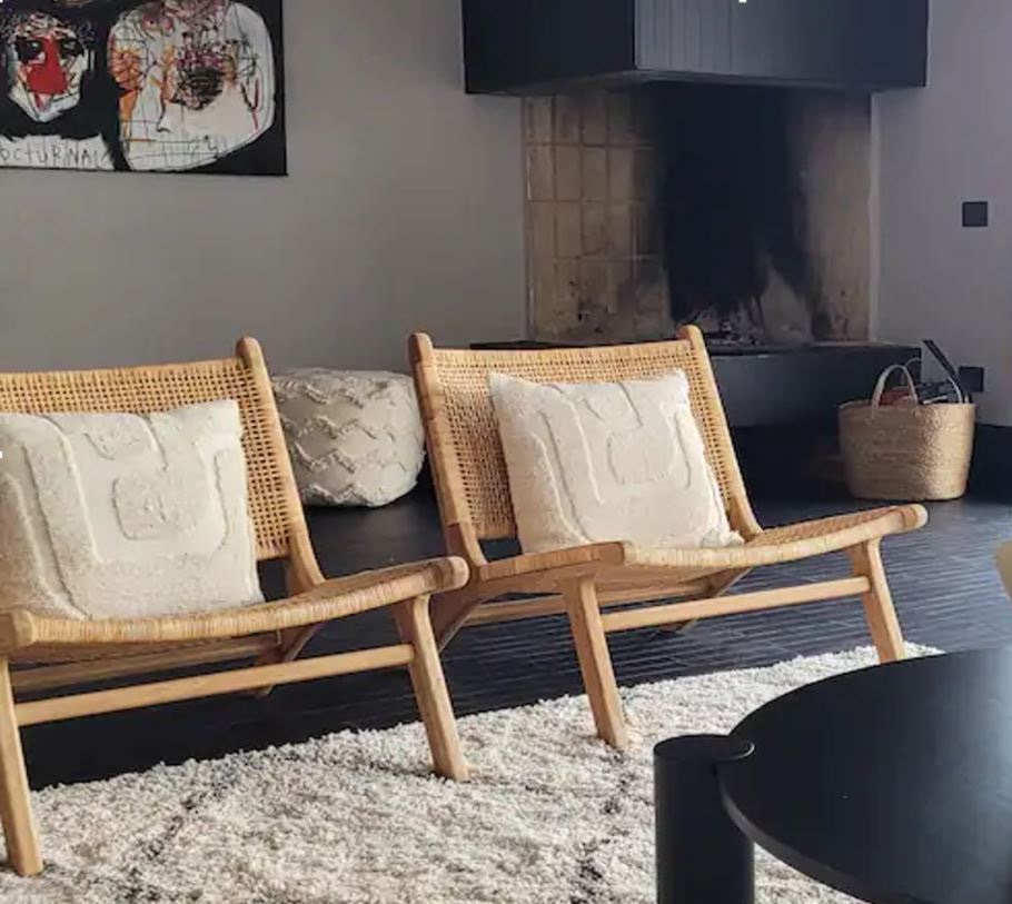 Loungesessel aus Rattan vor dem Kamin